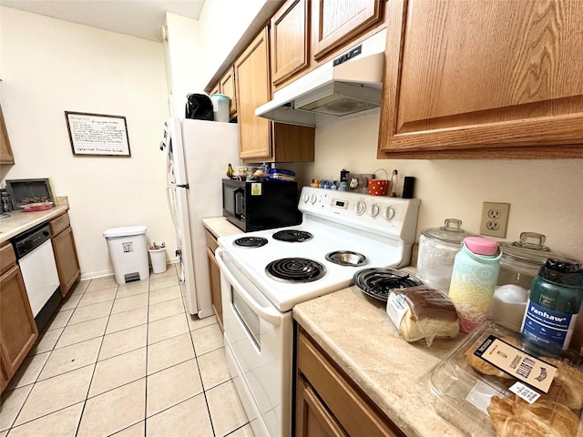 kitchen with white appliances, light tile patterned floors, under cabinet range hood, and light countertops