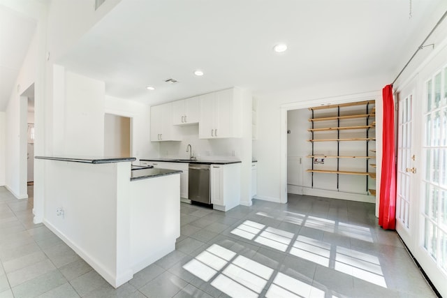 kitchen featuring dark countertops, plenty of natural light, white cabinets, and stainless steel dishwasher