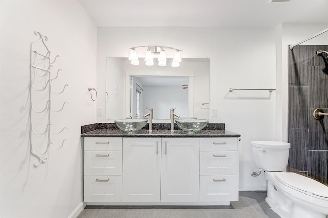 bathroom with a shower, vanity, toilet, and baseboards