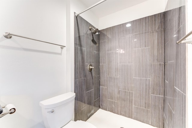 full bathroom with tiled shower and toilet