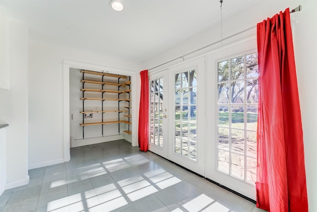 doorway to outside featuring tile patterned floors, baseboards, and french doors