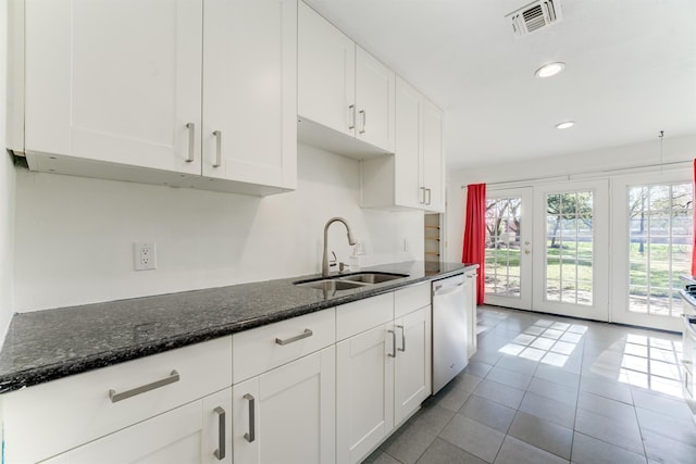 kitchen featuring dishwasher, white cabinetry, visible vents, and a sink