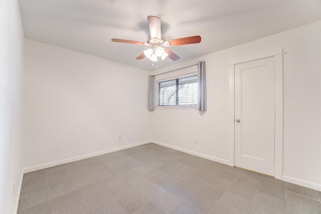 empty room featuring ceiling fan and baseboards