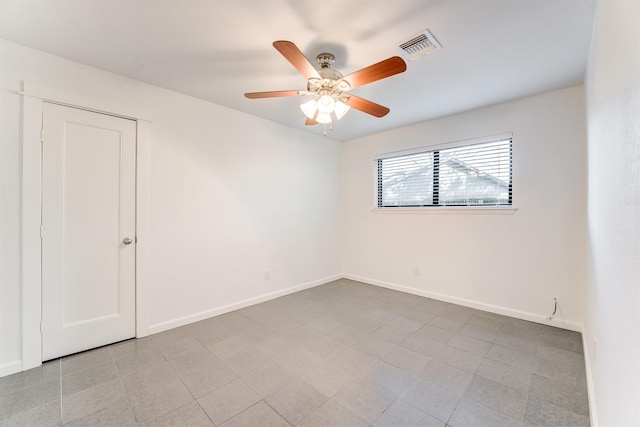 empty room with a ceiling fan, visible vents, and baseboards