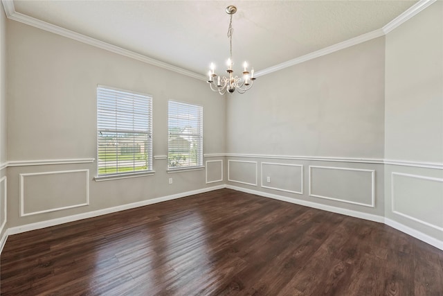 spare room with a decorative wall, ornamental molding, dark wood-style flooring, and an inviting chandelier