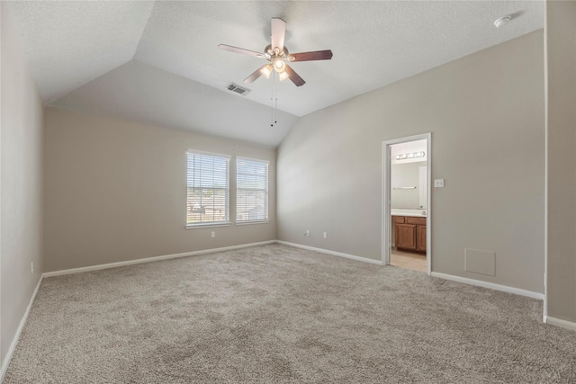 unfurnished room with lofted ceiling, ceiling fan, a textured ceiling, light colored carpet, and visible vents