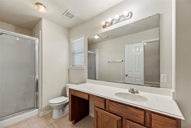 bathroom featuring toilet, vanity, visible vents, a shower stall, and tile patterned floors