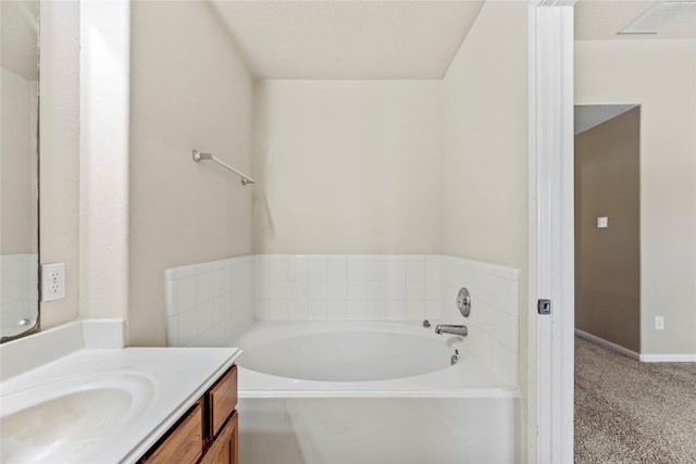 bathroom with visible vents, a bath, and vanity