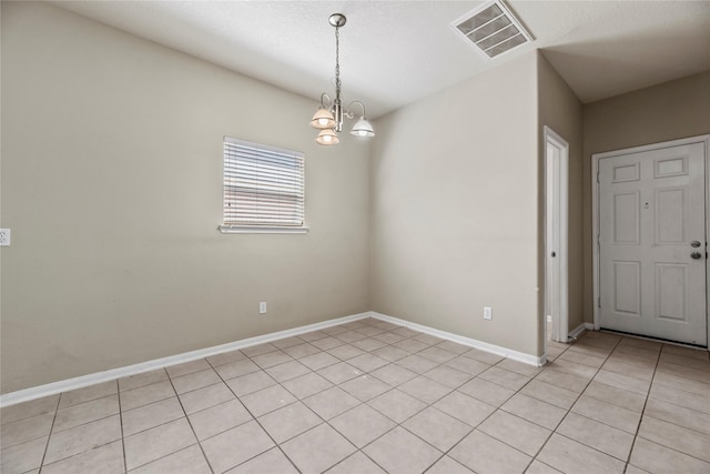 empty room with baseboards, visible vents, and a notable chandelier