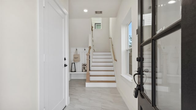 foyer entrance featuring recessed lighting, visible vents, marble finish floor, and stairway