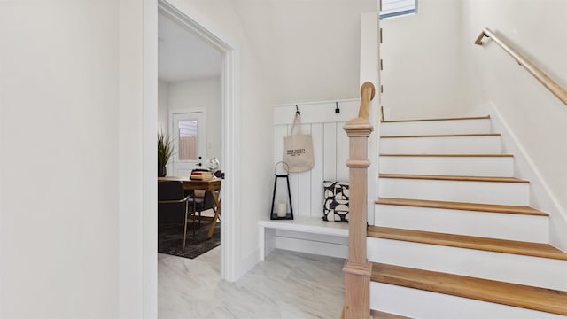 stairway featuring marble finish floor