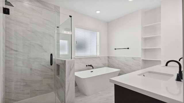 full bathroom featuring a freestanding tub, marble finish floor, a sink, a shower stall, and double vanity