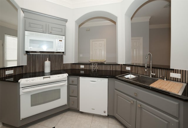 kitchen with white appliances, dark countertops, gray cabinets, and decorative backsplash