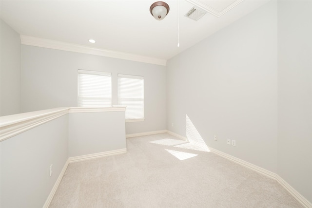 unfurnished room featuring light carpet, attic access, baseboards, visible vents, and ornamental molding