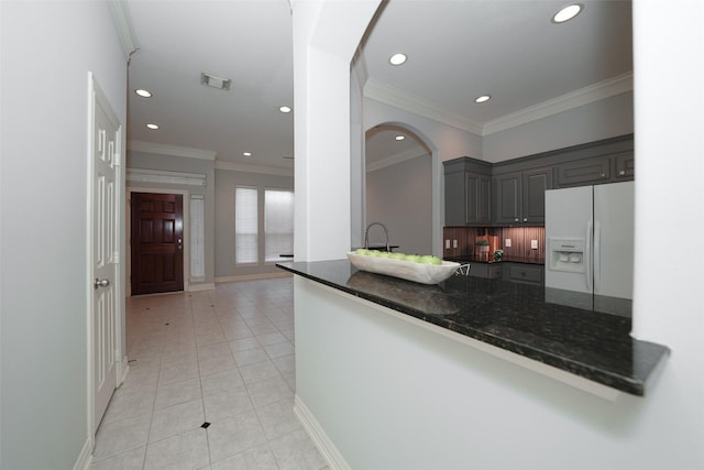 kitchen featuring white refrigerator with ice dispenser, crown molding, visible vents, gray cabinetry, and light tile patterned flooring