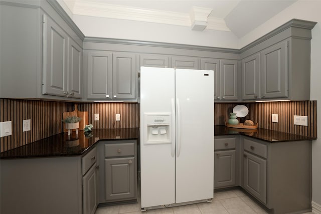 kitchen featuring light tile patterned floors, white refrigerator with ice dispenser, and gray cabinetry