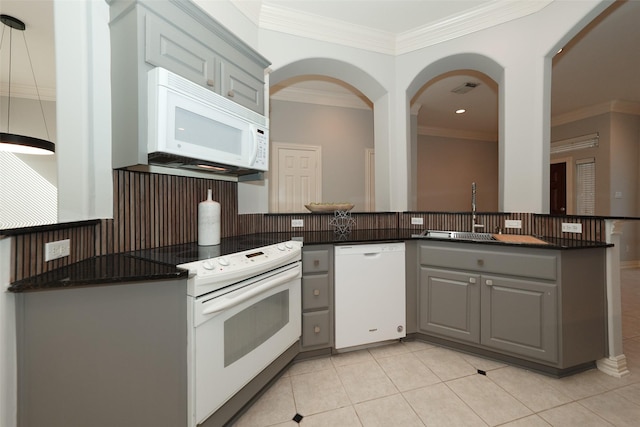 kitchen with gray cabinets, dark countertops, white appliances, and crown molding