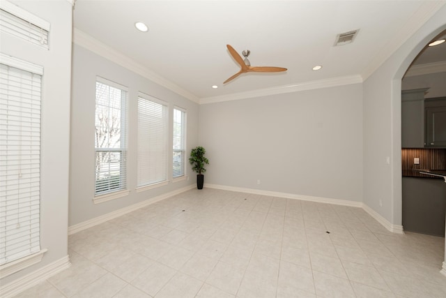 spare room with arched walkways, a ceiling fan, baseboards, visible vents, and crown molding