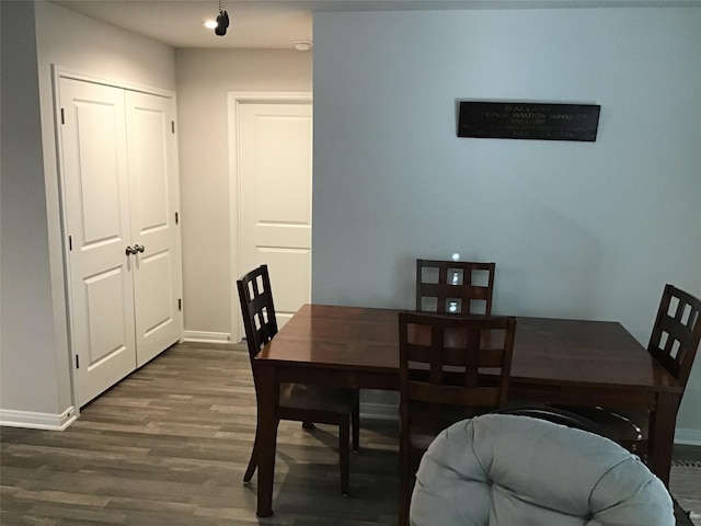 dining area featuring dark wood finished floors and baseboards