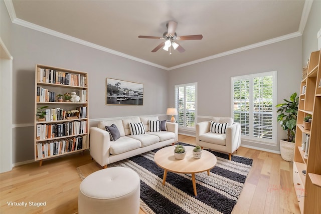 living area with ornamental molding, light wood-type flooring, and a ceiling fan