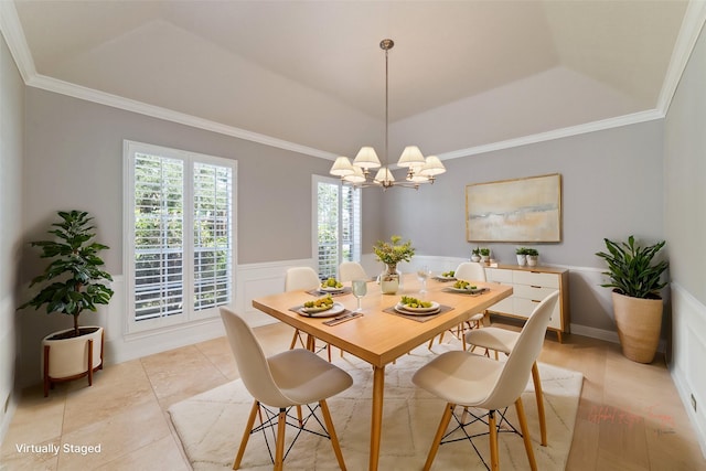 dining room featuring a wainscoted wall, ornamental molding, a decorative wall, and a notable chandelier