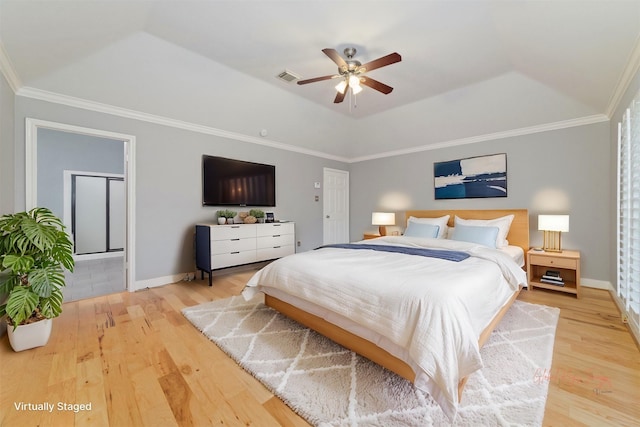 bedroom featuring ornamental molding, light wood finished floors, a raised ceiling, and visible vents