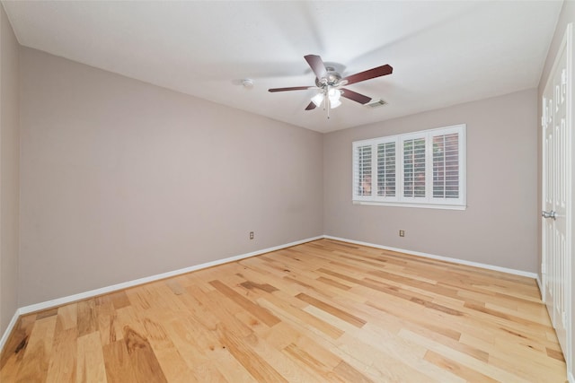 empty room featuring baseboards, visible vents, ceiling fan, and wood finished floors