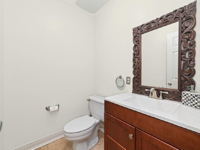 bathroom featuring toilet, tile patterned floors, baseboards, and vanity