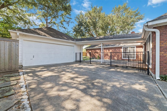 ranch-style home with driveway, brick siding, an attached garage, and fence