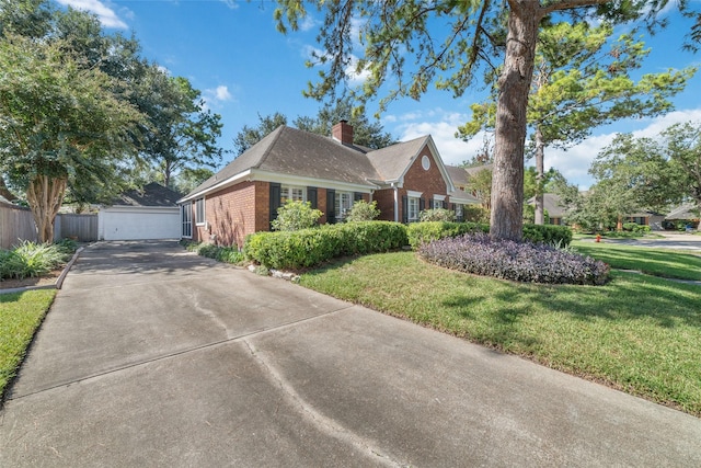 view of front of house with brick siding, a chimney, fence, an outdoor structure, and a front yard