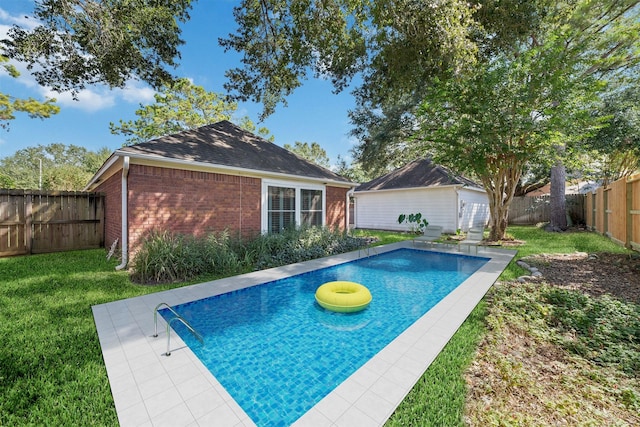 view of pool with a fenced in pool, a fenced backyard, a lawn, and an outdoor structure