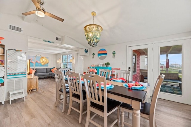 dining space featuring lofted ceiling, light wood-style floors, visible vents, and ceiling fan with notable chandelier