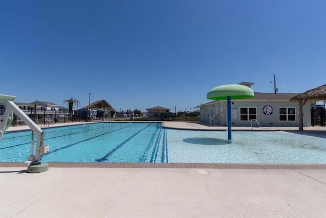 pool with a patio area and fence