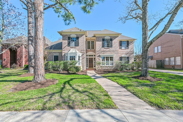 view of front facade with a front yard and brick siding