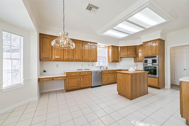 kitchen with visible vents, appliances with stainless steel finishes, brown cabinets, and light countertops