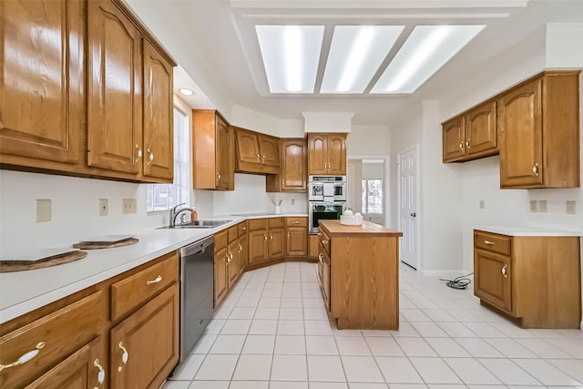 kitchen with light tile patterned floors, light countertops, appliances with stainless steel finishes, brown cabinetry, and a sink