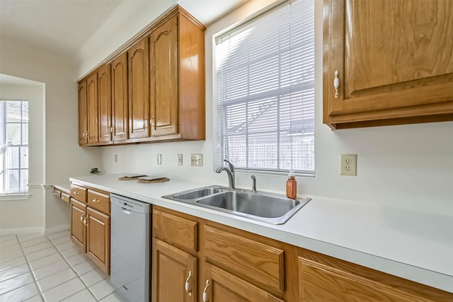 kitchen with dishwashing machine, a sink, light countertops, and brown cabinets