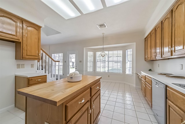 kitchen featuring hanging light fixtures, a healthy amount of sunlight, dishwasher, and wood counters