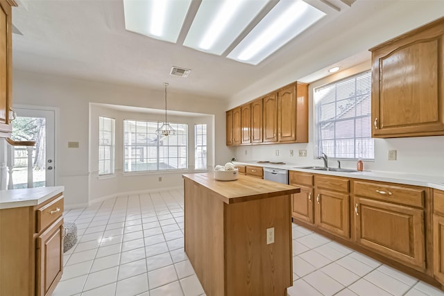 kitchen with light tile patterned floors, visible vents, dishwasher, wood counters, and a sink