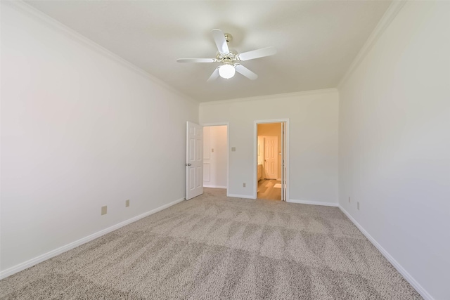 unfurnished bedroom featuring carpet, crown molding, ensuite bathroom, a ceiling fan, and baseboards