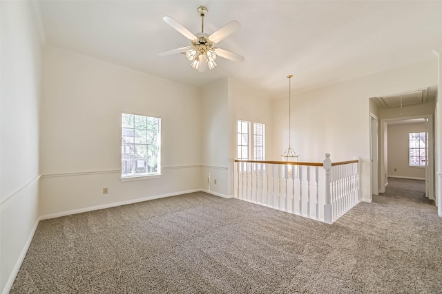 spare room with attic access, baseboards, ceiling fan, and carpet flooring