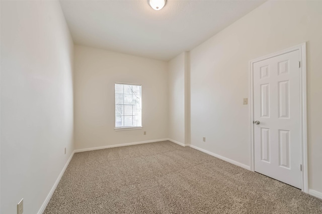 empty room featuring carpet flooring and baseboards