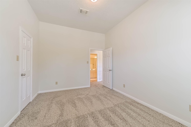 empty room featuring carpet, visible vents, and baseboards