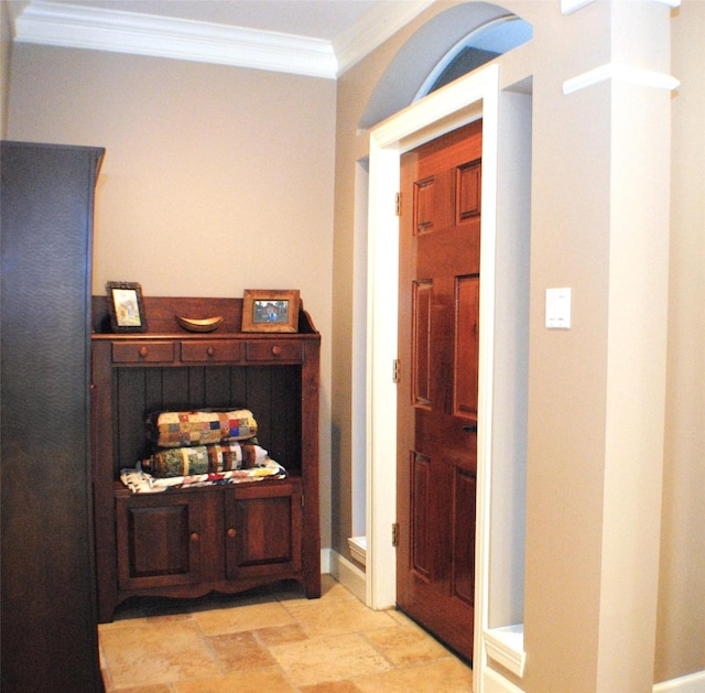 foyer entrance featuring stone finish floor and crown molding