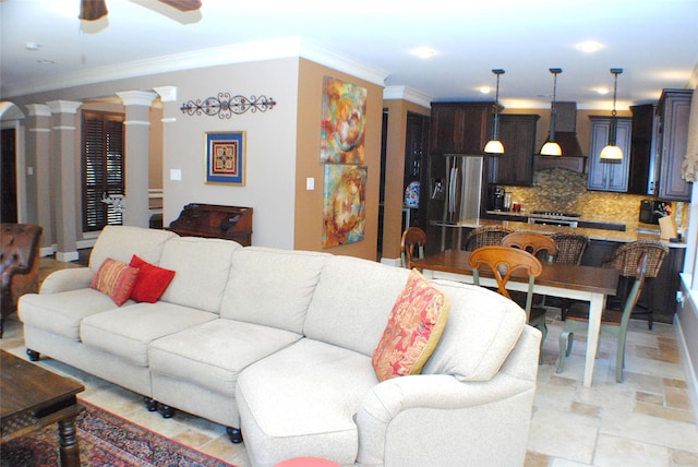 living area with decorative columns, a ceiling fan, and crown molding