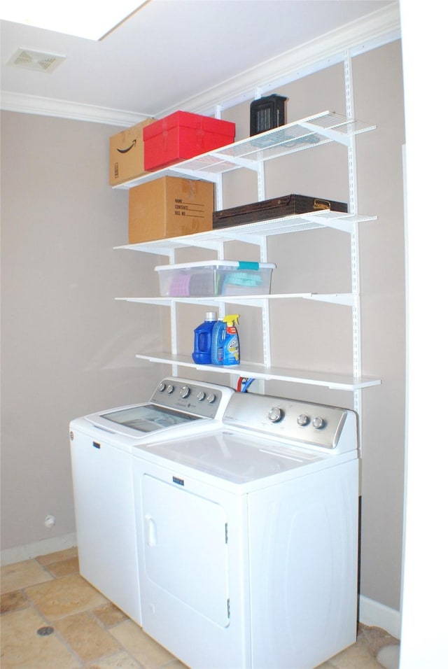 clothes washing area with visible vents, ornamental molding, washer and clothes dryer, baseboards, and laundry area