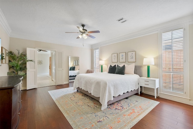 bedroom with dark wood-style floors, multiple windows, and ornamental molding