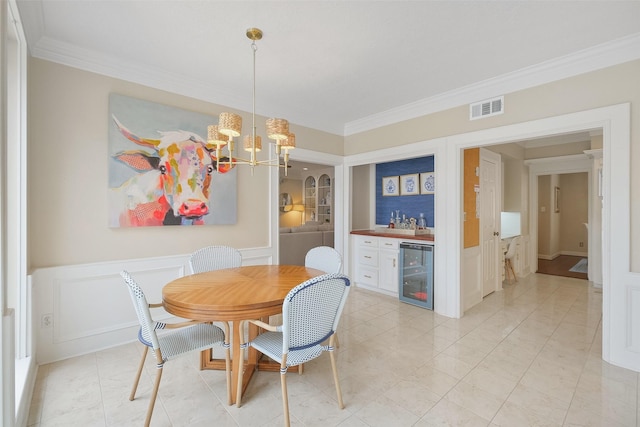 dining space featuring beverage cooler, crown molding, visible vents, and a decorative wall