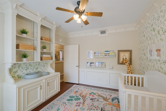 bedroom featuring ornamental molding, a wainscoted wall, visible vents, and wallpapered walls