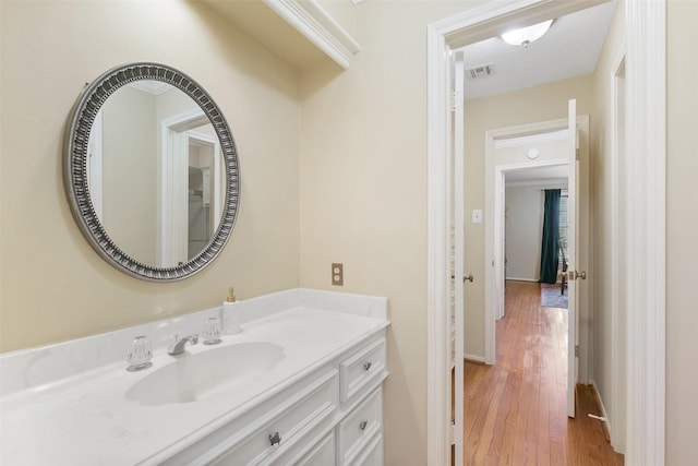 bathroom with visible vents, wood finished floors, and vanity